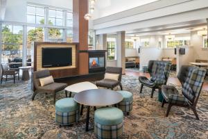 a lobby with a tv and chairs and a table at Residence Inn by Marriott Covington Northshore in Covington