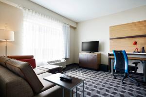 a hotel room with a couch and a desk with a computer at TownePlace Suites by Marriott St. Louis O'Fallon in O'Fallon