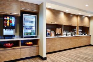 a restaurant with a counter with a refrigerator at TownePlace Suites by Marriott St. Louis O'Fallon in O'Fallon