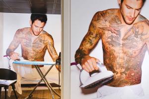 a man with tattoos on his arms using a iron at Moxy Munich Airport in Oberding
