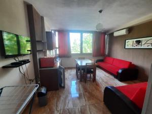 a living room with a red couch and a table at Elio's Holiday Home in Pogradec