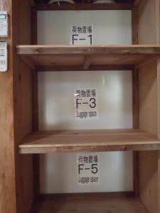 un estante en una tienda con letreros. en Kerama Backpackers en Tokashiki