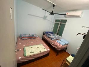Kampong Tanah MerahにあるMr Singh Homestayのベッド2台と窓が備わる小さな客室です。