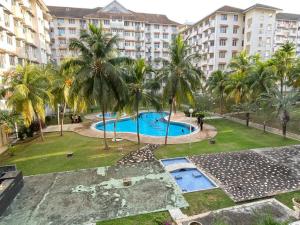 Kampong Tanah Merah的住宿－Mr Singh Homestay，享有棕榈树和建筑的游泳池的顶部景致