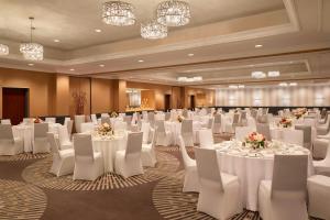 a banquet hall with white tables and white chairs at Courtyard by Marriott Toronto Downtown in Toronto
