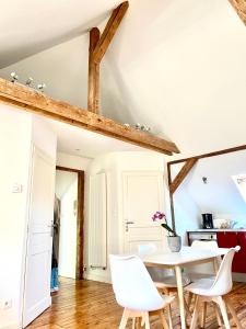 ein Esszimmer mit einem Tisch und weißen Stühlen in der Unterkunft L’appartement du Parc in Longeville-lès-Metz