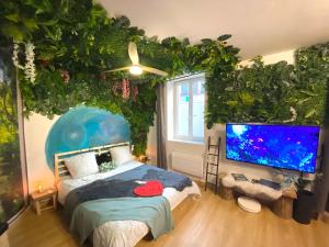 1 dormitorio con una pared de pescado, 1 cama y TV de pantalla grande en Le monde D avatar avec Balneo et table de massage, en L'Arbresle