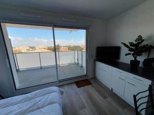 ein Schlafzimmer mit einem Bett und einem großen Fenster in der Unterkunft appartement remblai saint hilaire de riez in Saint-Hilaire-de-Riez