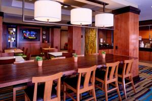 Fairfield Inn and Suites New Buffalo في نيو بافالو: غرفة طعام كبيرة مع طاولة وكراسي خشبية كبيرة