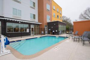 une grande piscine en face d'un bâtiment dans l'établissement Fairfield Inn & Suites by Marriott Tyler South, à Tyler