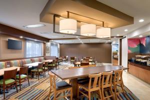 un restaurant avec une grande table et des chaises en bois dans l'établissement Fairfield Inn & Suites Salt Lake City Airport, à Salt Lake City