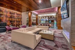 a lobby with a couch and a bar at Courtyard by Marriott Raleigh Cary/Parkside Town Commons in Cary