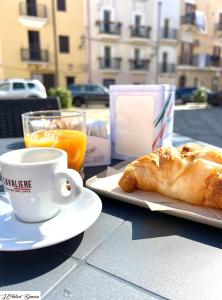 einen Tisch mit einer Tasse Kaffee und einem Teller mit Gebäck in der Unterkunft L’Antica Dimora in Bari