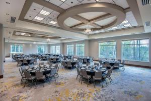 a banquet hall with tables and chairs in a room with windows at Courtyard by Marriott Raleigh Cary/Parkside Town Commons in Cary