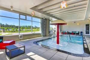 a large pool with an umbrella in a building at Courtyard by Marriott Raleigh Cary/Parkside Town Commons in Cary