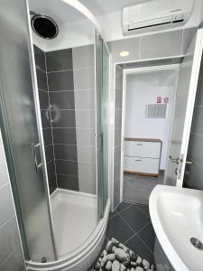 y baño con ducha y lavamanos. en Apartman Solin 1, parking en Solin