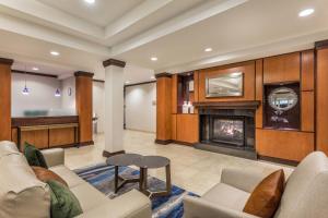 a living room with a fireplace and a couch at Fairfield Inn and Suites by Marriott Madison East in Madison