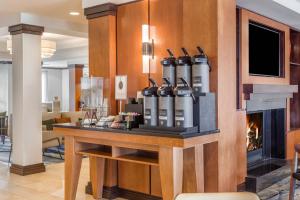 a lobby with a table with a fireplace at Fairfield Inn and Suites by Marriott Madison East in Madison