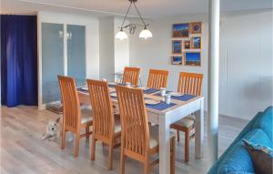 una mesa de comedor con sillas y un perro sentado a su alrededor en Elfrank, en Bergen aan Zee