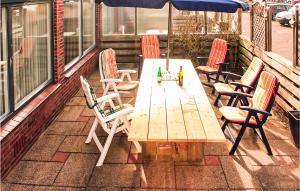 Una mesa y sillas de madera en un patio. en Elfrank, en Bergen aan Zee