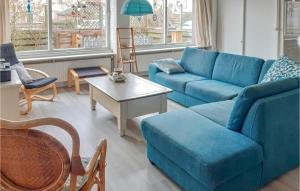 Una sala de estar con un sofá azul y una mesa. en Elfrank, en Bergen aan Zee 4 fotos más