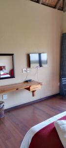 Zimmer mit einem TV an der Wand und einem Tisch in der Unterkunft ThakhuBrunfelsia in Secunda