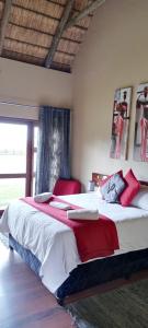 um quarto com uma cama grande com detalhes em vermelho em ThakhuBrunfelsia em Secunda