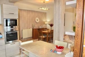 a kitchen and living room with a table and a dining room at SuiteViewPoros-Luxury Apartment in Galatas in Galatas