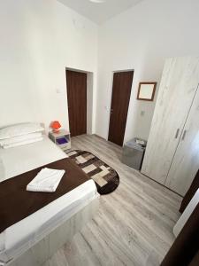 a white bedroom with a bed and wooden floors at Hotel Continental in Iaşi