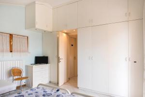 ein Schlafzimmer mit weißen Schränken und einem Bett in einem Zimmer in der Unterkunft N164 - Numana, bilocale con meravigliosa vista mare in Numana