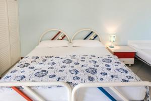 ein Schlafzimmer mit einem Bett mit einer blau-weißen Decke in der Unterkunft N164 - Numana, bilocale con meravigliosa vista mare in Numana