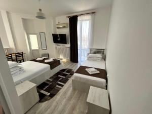 Cette petite chambre comprend deux lits et une télévision. dans l'établissement Hotel Continental, à Iaşi