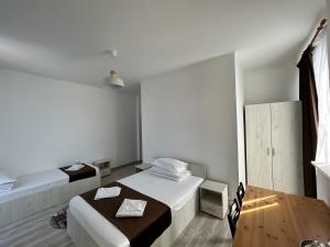 Habitación blanca con 2 camas y suelo de madera. en Hotel Continental, en Iaşi