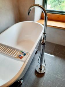 a sink with a faucet next to a bath tub at Longstone Luxury Country Boutique Two Bedroom Cottage, Exmoor, Challacombe, North Devon in Challacombe