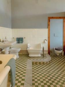 uma casa de banho com 2 WC, um lavatório e uma banheira em Villa Biancardi - Un posto un Sogno em Codogno