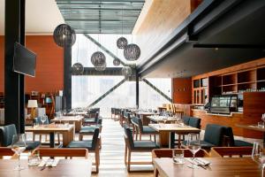 a restaurant with wooden tables and chairs and a large window at Courtyard by Marriott Mexico City Toreo in Mexico City