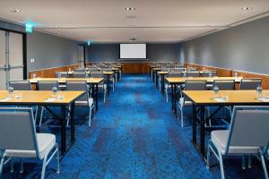 a conference room with tables and chairs and a screen at Courtyard by Marriott Mexico City Toreo in Mexico City
