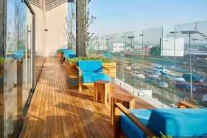 a balcony with blue chairs and a view of a city at Courtyard by Marriott Mexico City Toreo in Mexico City