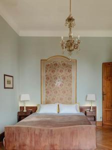 um quarto com uma cama grande e um lustre em Villa Biancardi - Un posto un Sogno em Codogno