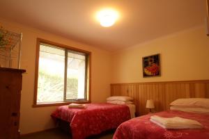 a bedroom with two beds and two lamps at Abs by the Bay in Taranna