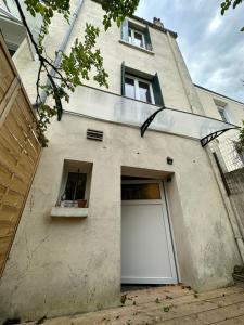a building with a white garage door and a window at La Maison de l'Espérance in Tours