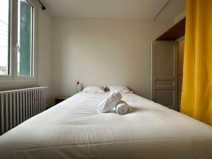 a white bed in a room with a window at La Maison de l'Espérance in Tours