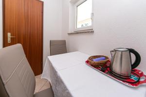 einen Tisch mit einem Wasserkocher und einem Korb darauf in der Unterkunft Apartmani Jakiruša in Brela