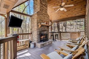 eine abgeschirmte Veranda mit einem Kamin und Stühlen in der Unterkunft Blue Ridge Bear Bungalow in Blue Ridge
