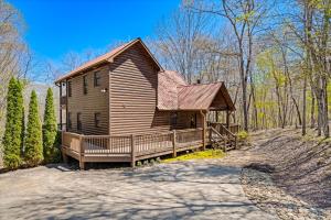 eine Blockhütte im Wald mit einer Veranda in der Unterkunft Blue Ridge Bear Bungalow in Blue Ridge