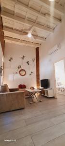 セビリアにあるAcogedor Apartamento en Triana Sevillaのリビングルーム(ソファ、テレビ付)