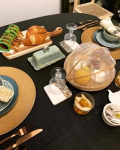 ein schwarzer Tisch mit Teller mit Lebensmitteln drauf in der Unterkunft Boutique B&B- The Riverside Retreat in Jarnac