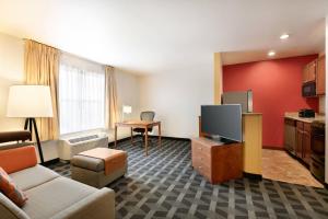 a hotel room with a couch and a flat screen tv at TownePlace Suites Gaithersburg in Gaithersburg