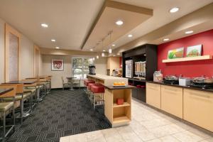 a restaurant with red walls and tables and chairs at TownePlace Suites Gaithersburg in Gaithersburg