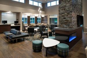 a lobby with a bar and chairs and a fireplace at Residence Inn by Marriott St Louis Chesterfield in Chesterfield